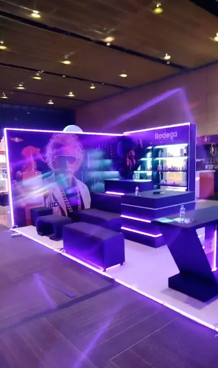 Stand con iluminación morada y sala de exhibición